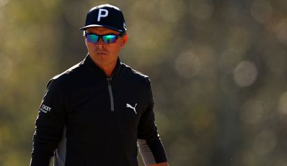 Fowler stares on whilst wearing sunglasses and a black hat