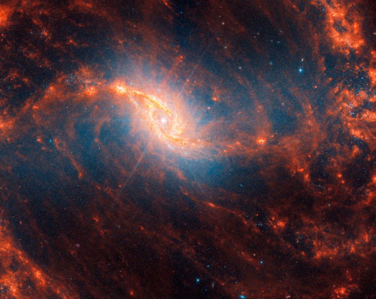 La galaxia espiral NGC 1365 con picos de difracción rosados ​​que podrían indicar un agujero negro supermasivo activo en el corazón de esta galaxia