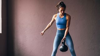 a photo of a woman holding a kettlebell