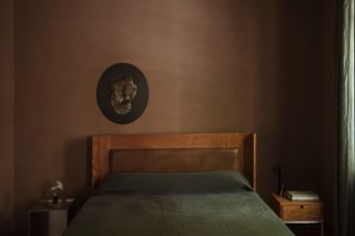 a small bedroom with dark brown walls