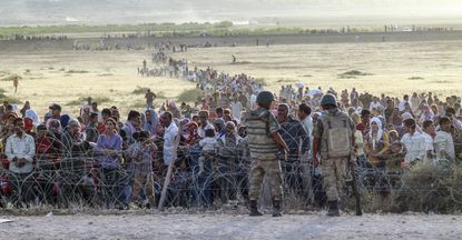 Syrian refugees are held at the border with Turkey.