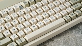 The Lofree Block keyboard on a stone surface with a blue wall in the background.