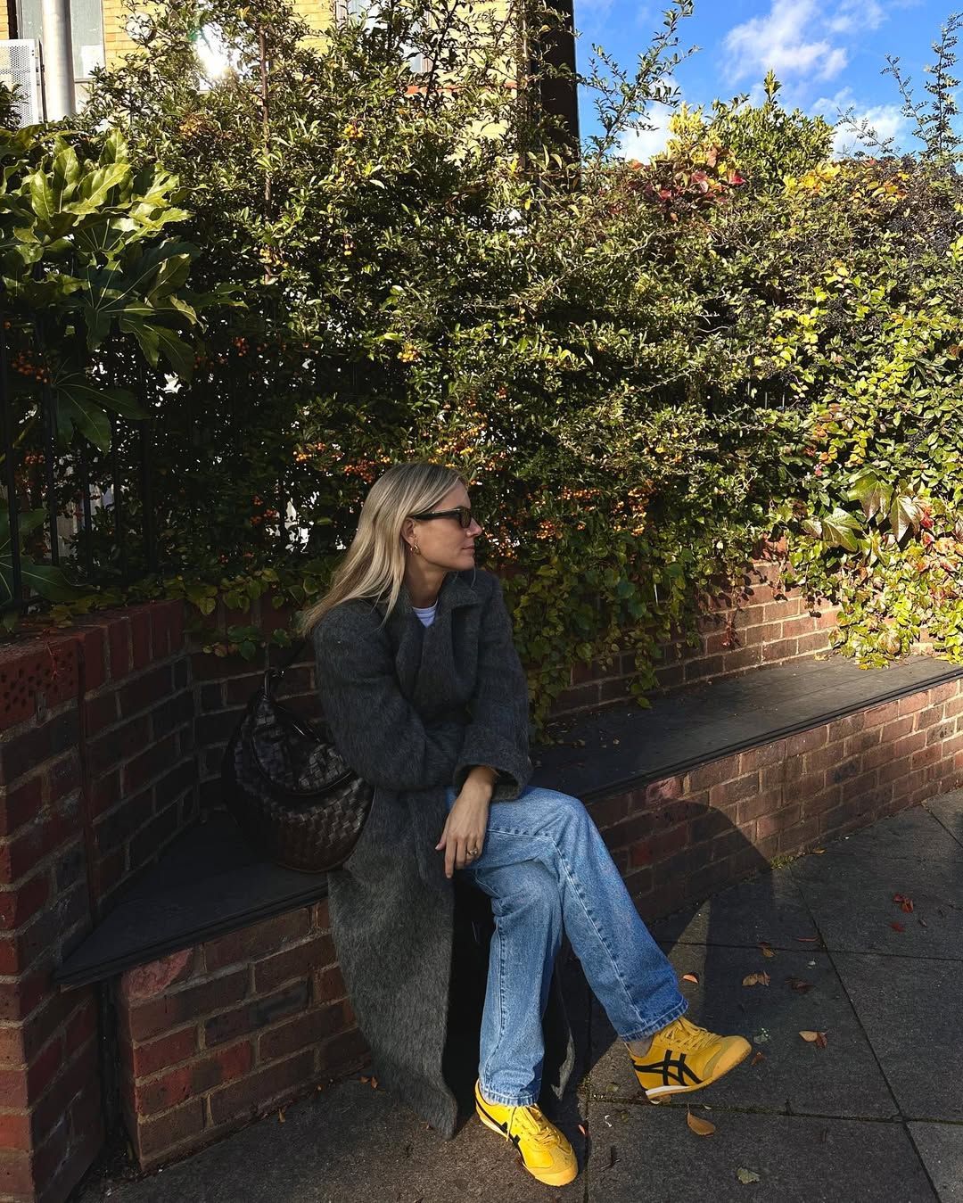 @lucywilliams02 wearing yellow trainers, jeans and long coat