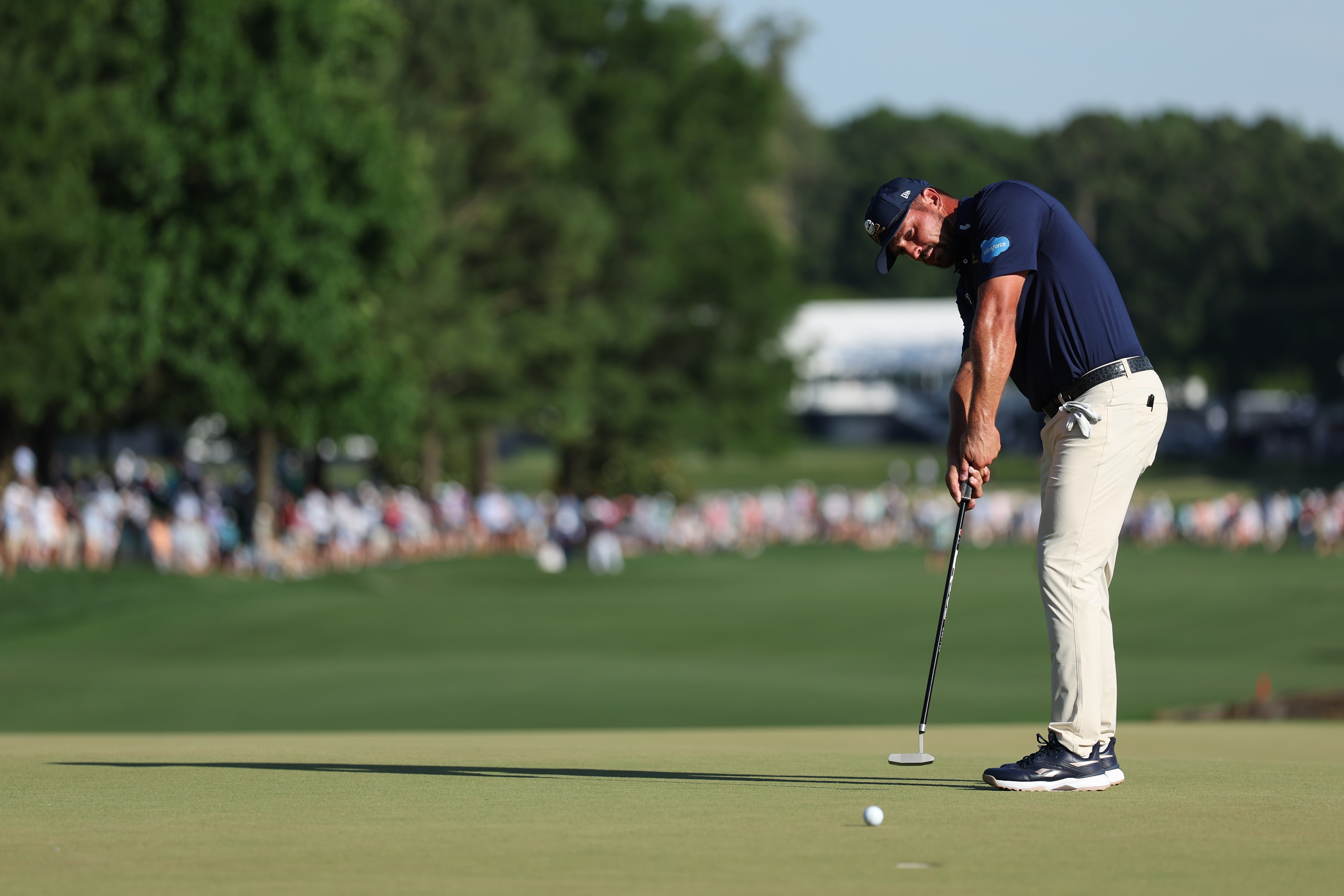 Bryson DeChambeau hits a putt on the 18th green