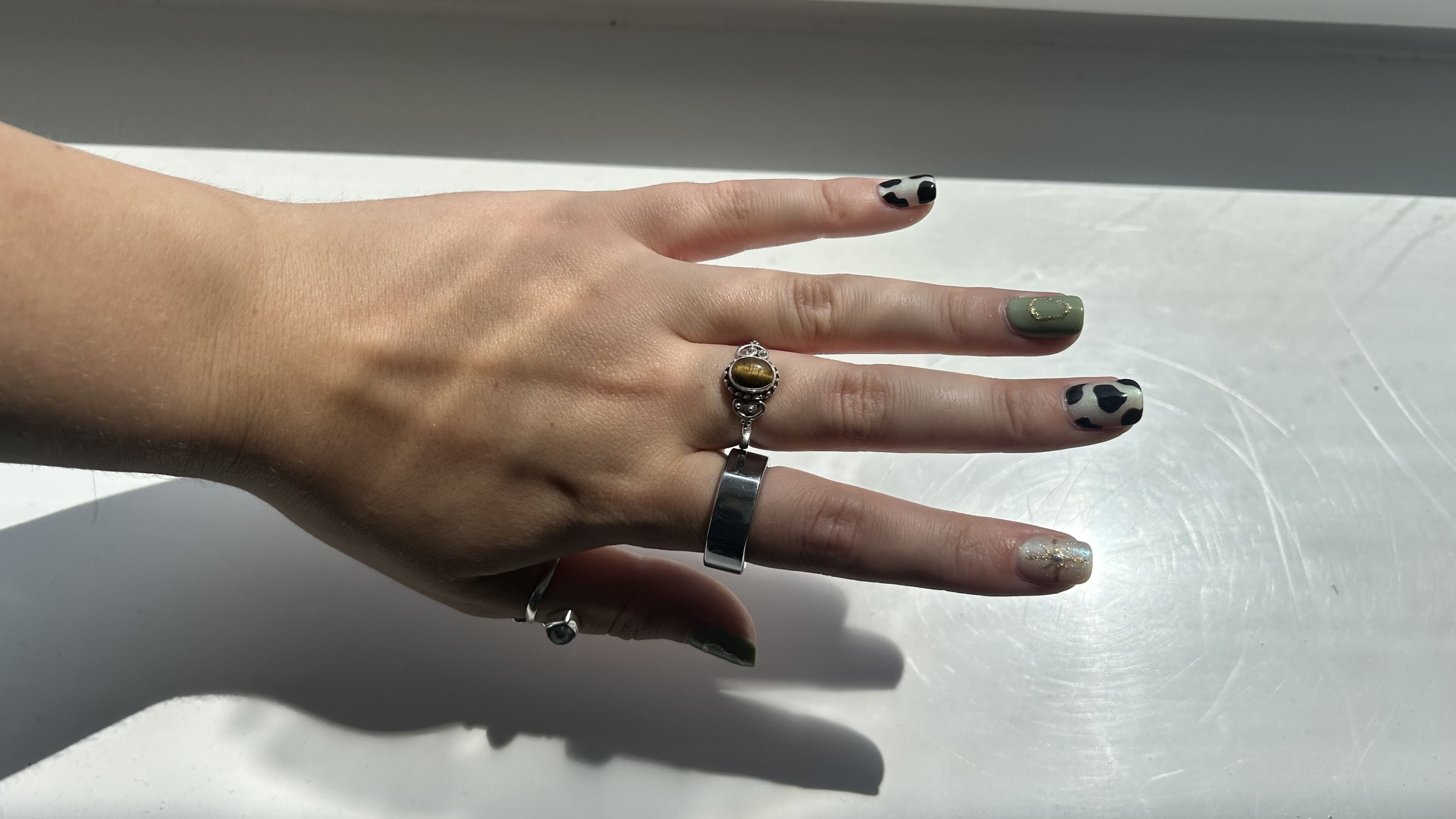 Oura Ring 3 in Heritage Silver on left index finger of a woman's hand.