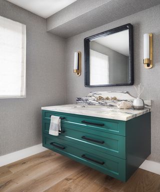 Teal wooden bathroom vanity with square mirror above