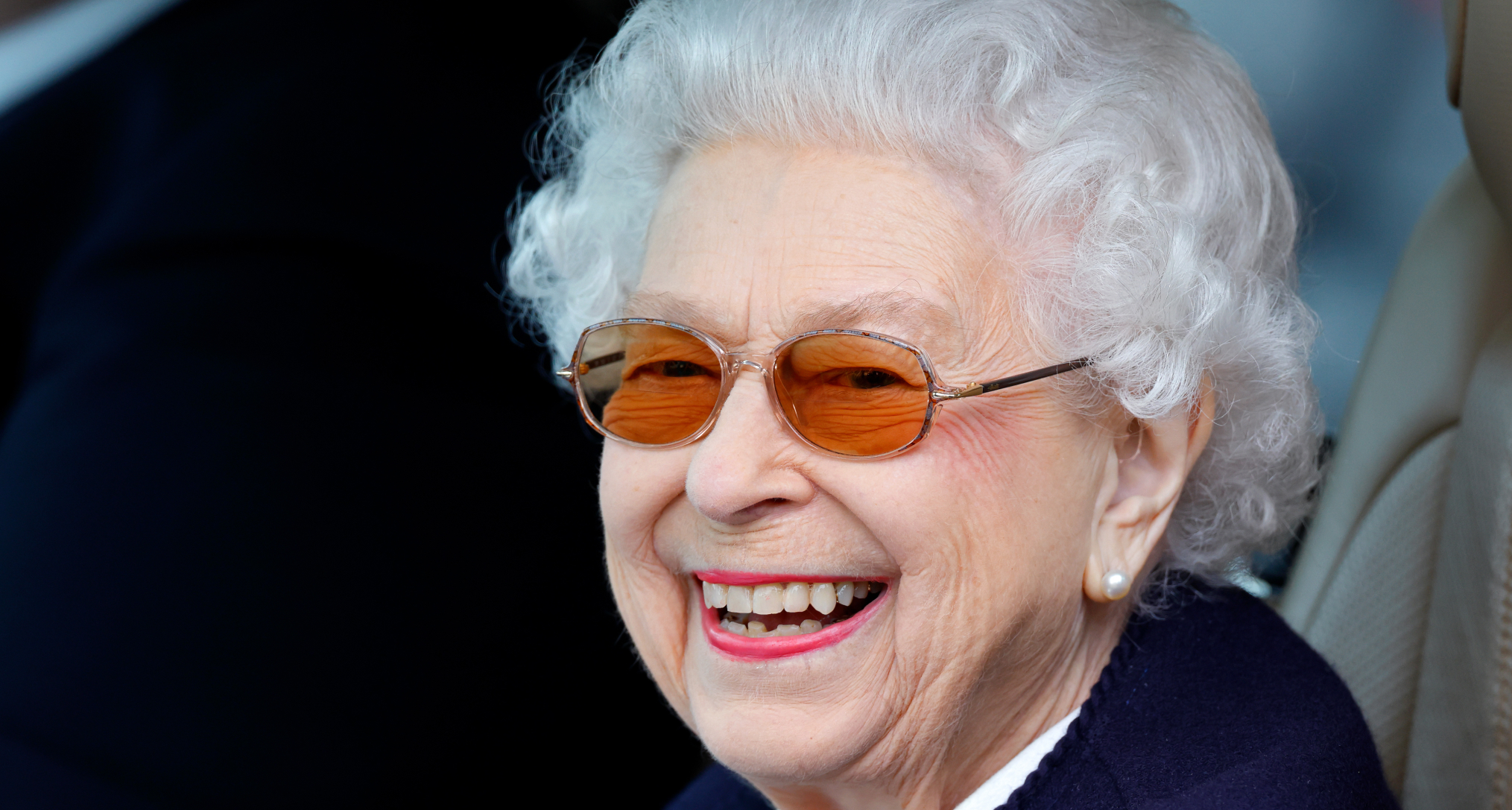 Queen Elizabeth wearing sunglasses and smiling