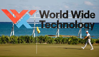 Hovland walks in front of the World Wide Technology Championship At Mayakoba banner