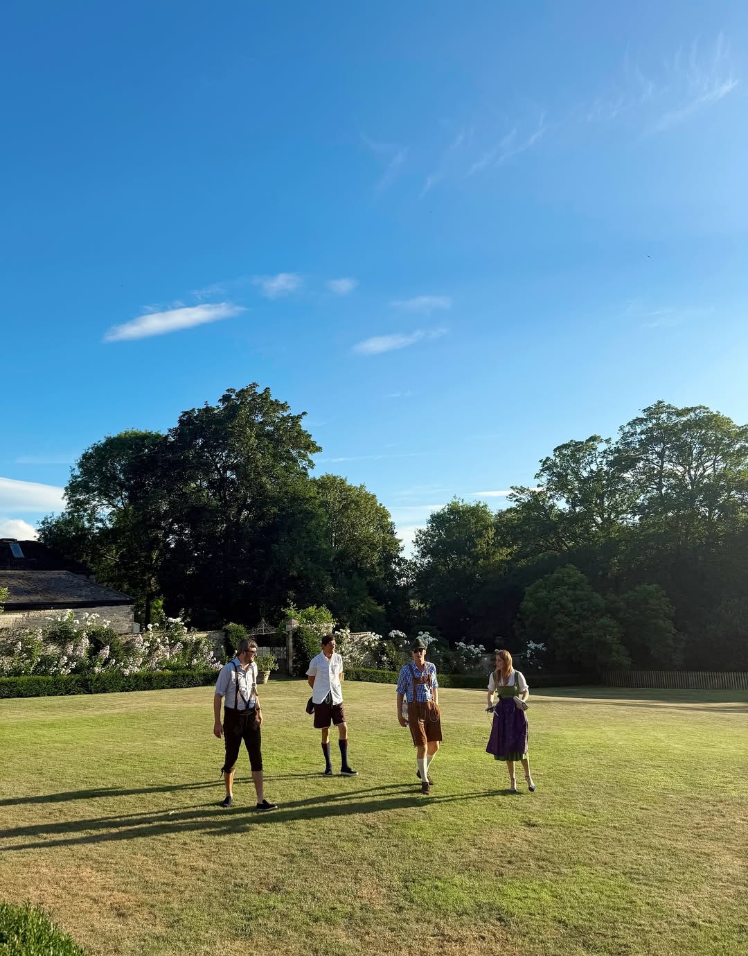 Princess Beatrice wearing a dirndl walking across a field with friends
