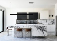 marble island with black and white cabinets 