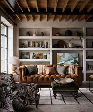 Neutral living room with shelving, leather sofa, patterned lounge chair