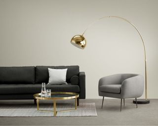 Bow Large Arc Overreach Floor Lamp in living room hanging over grey sofa