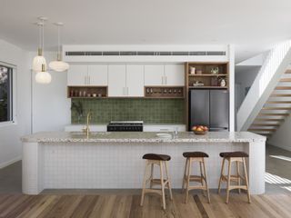 A white kitchen with green tiles