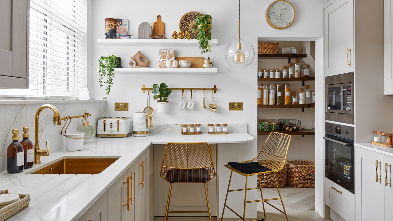 White kitchen with open shelves and gold bar stools and tap