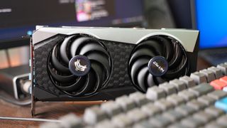 AMD Radeon RX 6000 Series Graphics Card on top wooden desk beside a keyboard