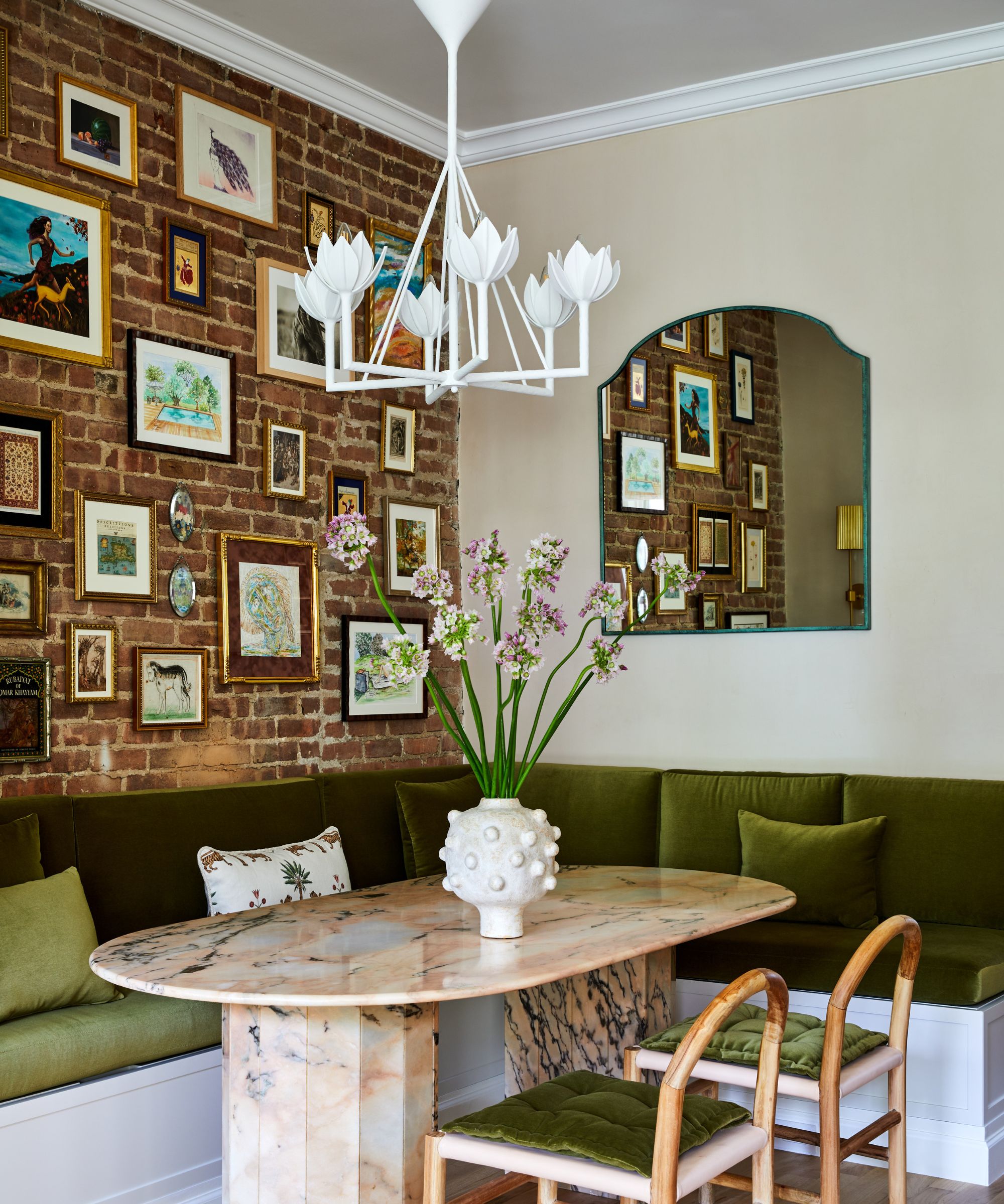 dining nook with statement lighting and an exposed brick wall
