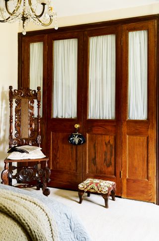 wooden panelled wardrobe with chair
