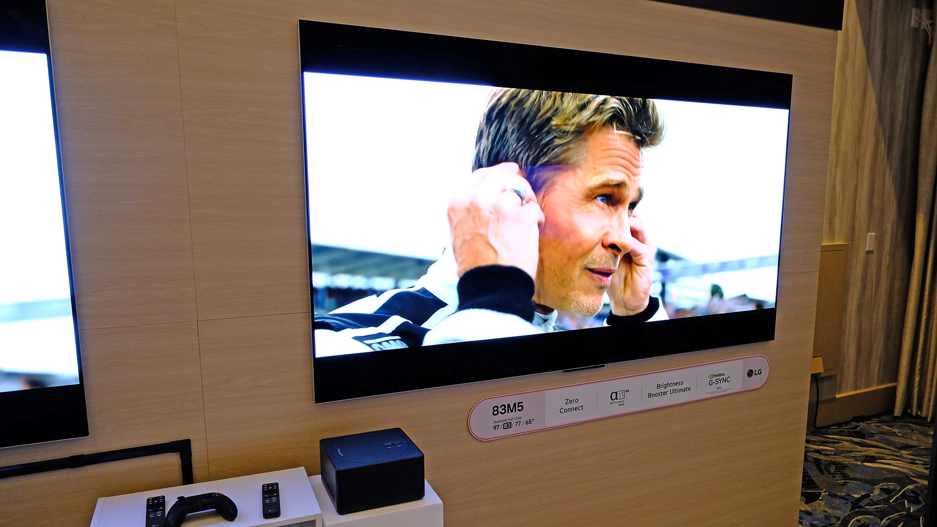 The LG M5 TV mounted on a wall. with the Zero Connect box next to it