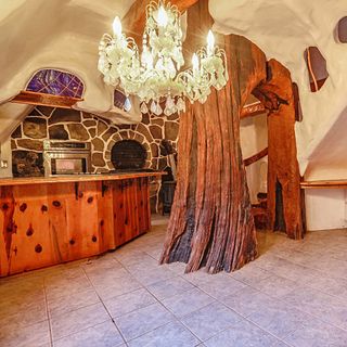 room with stone walls chandelier and fireplace