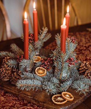 Candle holder centerpiece with pinecones and branches