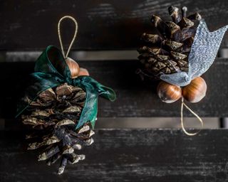 Hanging Christmas ornaments made from pine cone and hazelnut