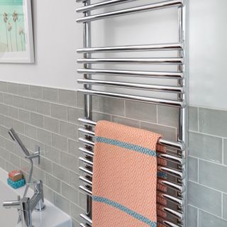 bathroom with towel rail and grey tiles