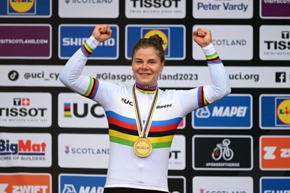 Lotte Kopecky cheering while wearing a rainbow jersey