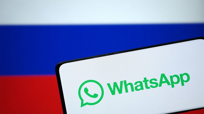 Smartphone displaying WhatsApp logo in front of Russian flag