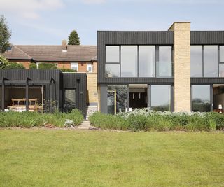 The front view of a two storey self build home with a smaller separate work studio next door