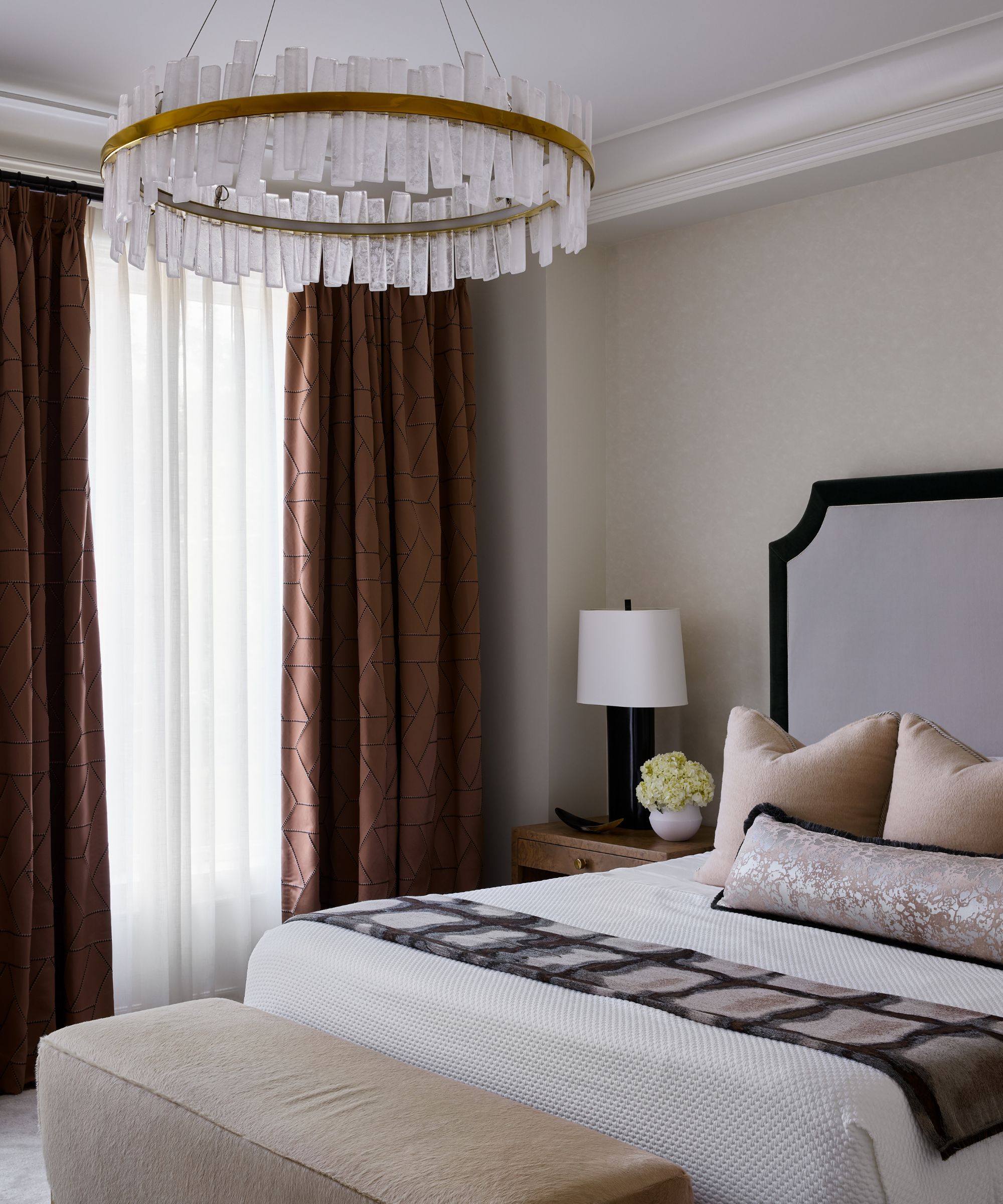 bedroom with neutral walls, brown curtains, and light peach cushions