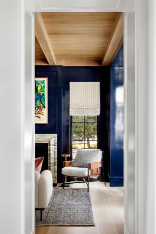doorway to formal living room with dark walls and light wood paneled ceiling view to fireplace
