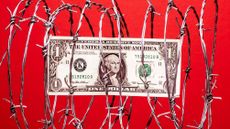 $1 US dollar bill inside coil of steel barbed wire, red background