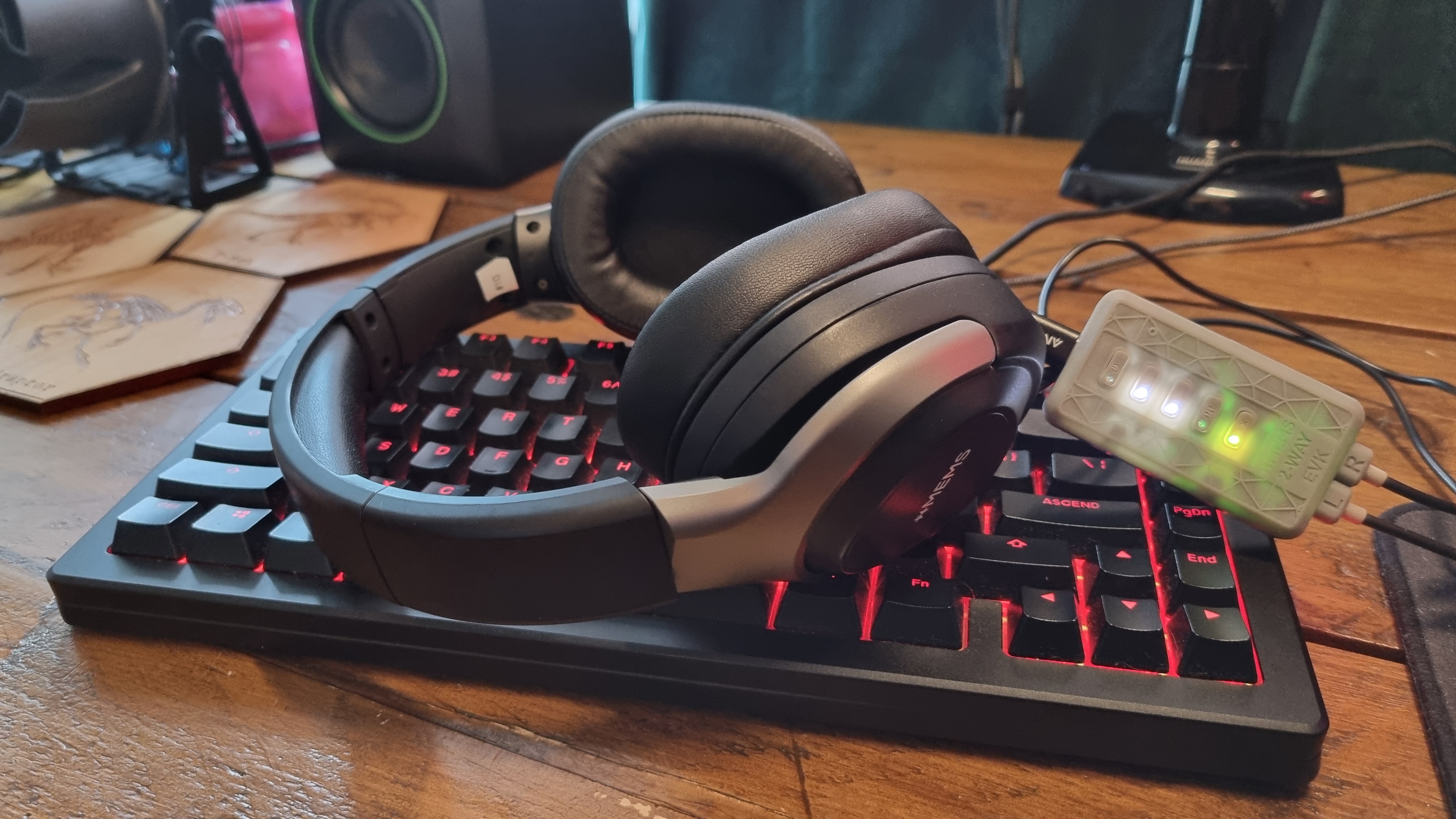 The xMEMS prototype gaming headset sitting atop a keyboard with the control box in shot