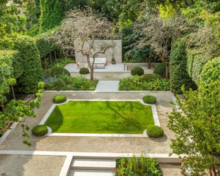 city garden with grass parterre, yew domes and evergreen structure with limestone hard landscaping
