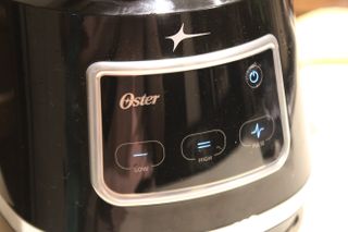 The control panel of the Oster 10-Cup Food Processor with Easy-Touch, with three touch buttons