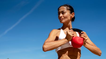 a strong woman holding a kettlebell