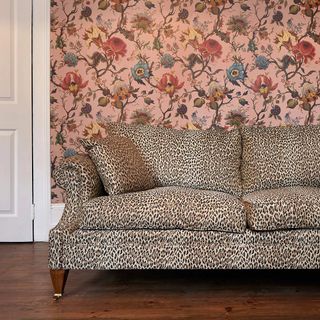 living room with leopard print sofa and wooden floor and wall with flower design wallpaper