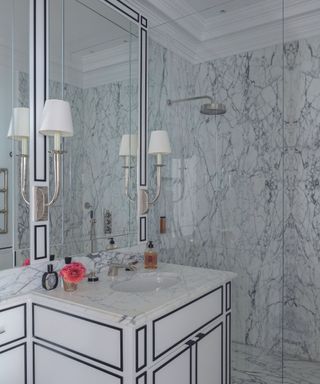 bathrom with grey veined marble and white cabinetry