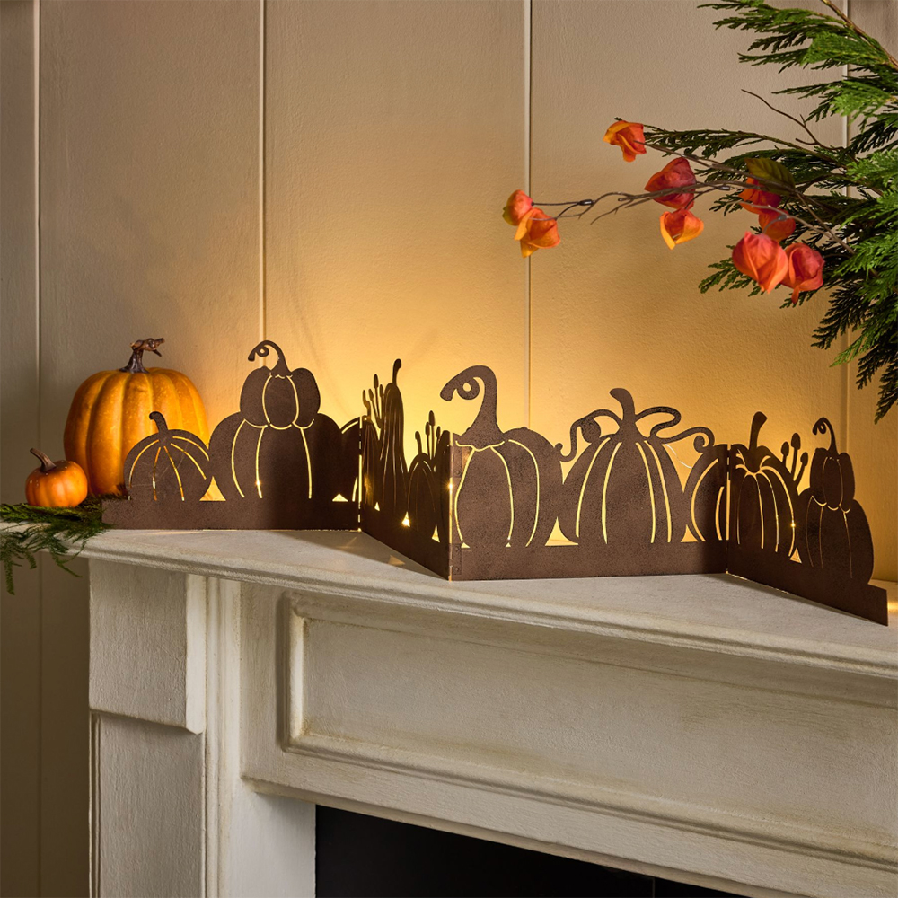 Pumpkin light up metal garland on a mantlepiece