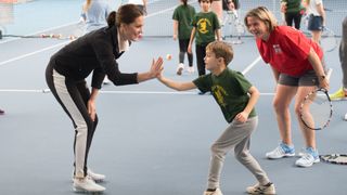 Kate Middleton with a young child at a tennis court