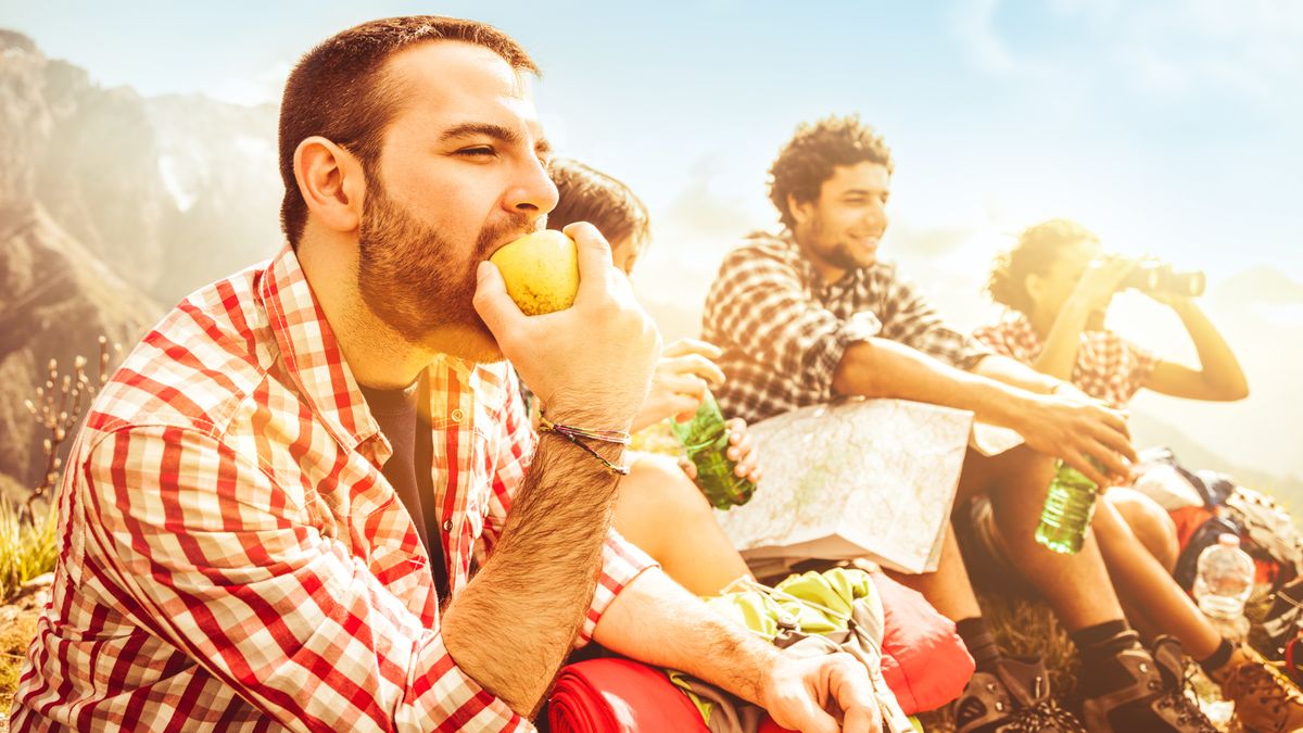 Hikers eating an apple on the trail