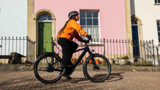 Woman on bike riding past houses