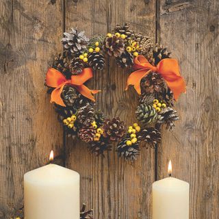 Autumn wreath with pine cones, yellow berries and orange bows