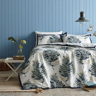bedroom with botanical bedsheet and blue wall