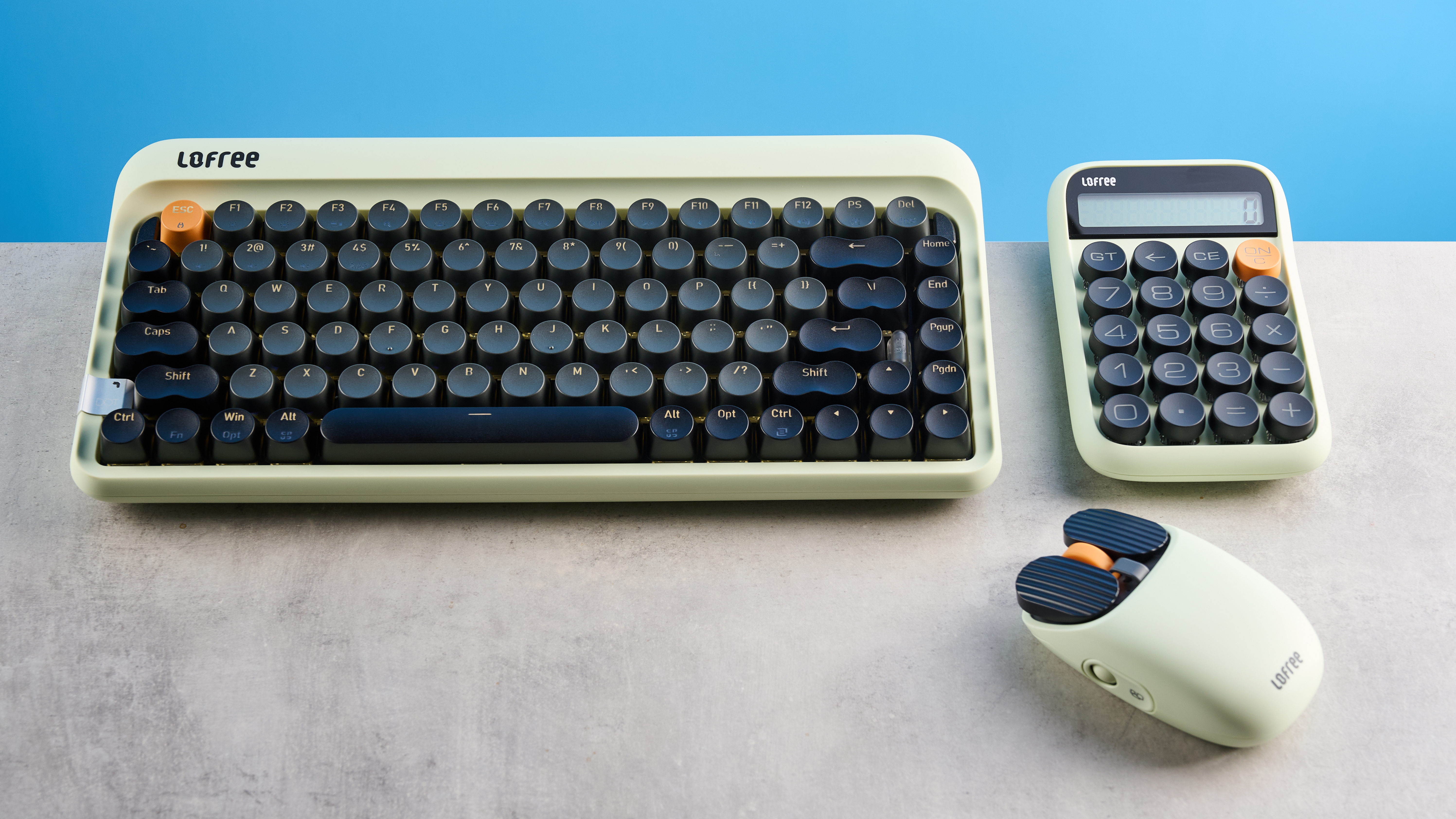 The Lofree DOT on a stone surface next to the matching mouse and calculator pad