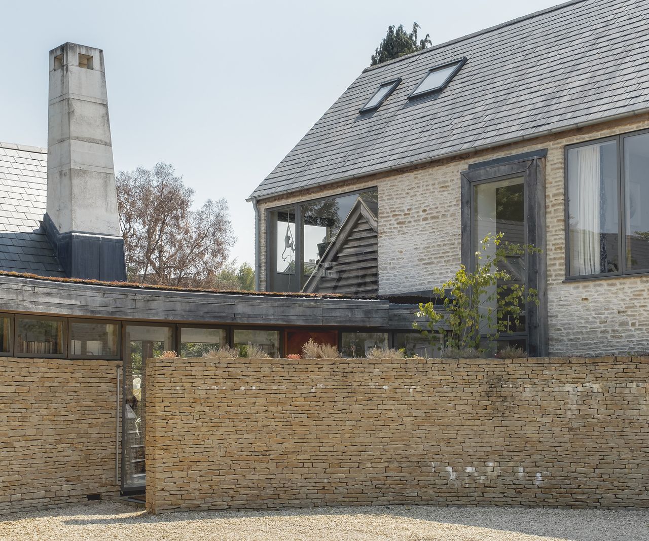 The exterior of a self build with a light brick wall