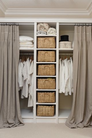 Earthy toned closet with basket organizers and curtains on each side