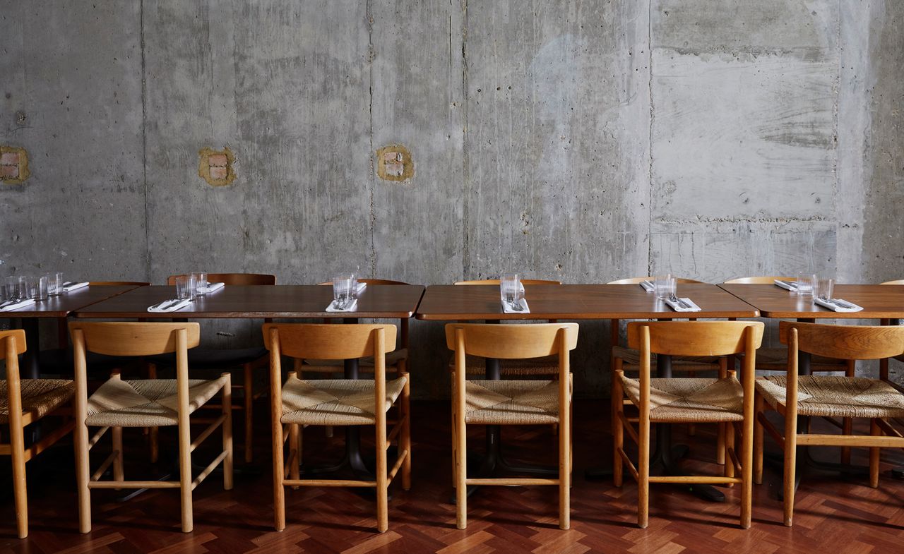 wooden tables and chairs and stone wall