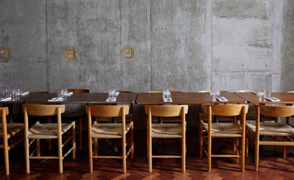 wooden tables and chairs and stone wall