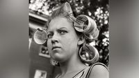 Woman wearing hair curlers.